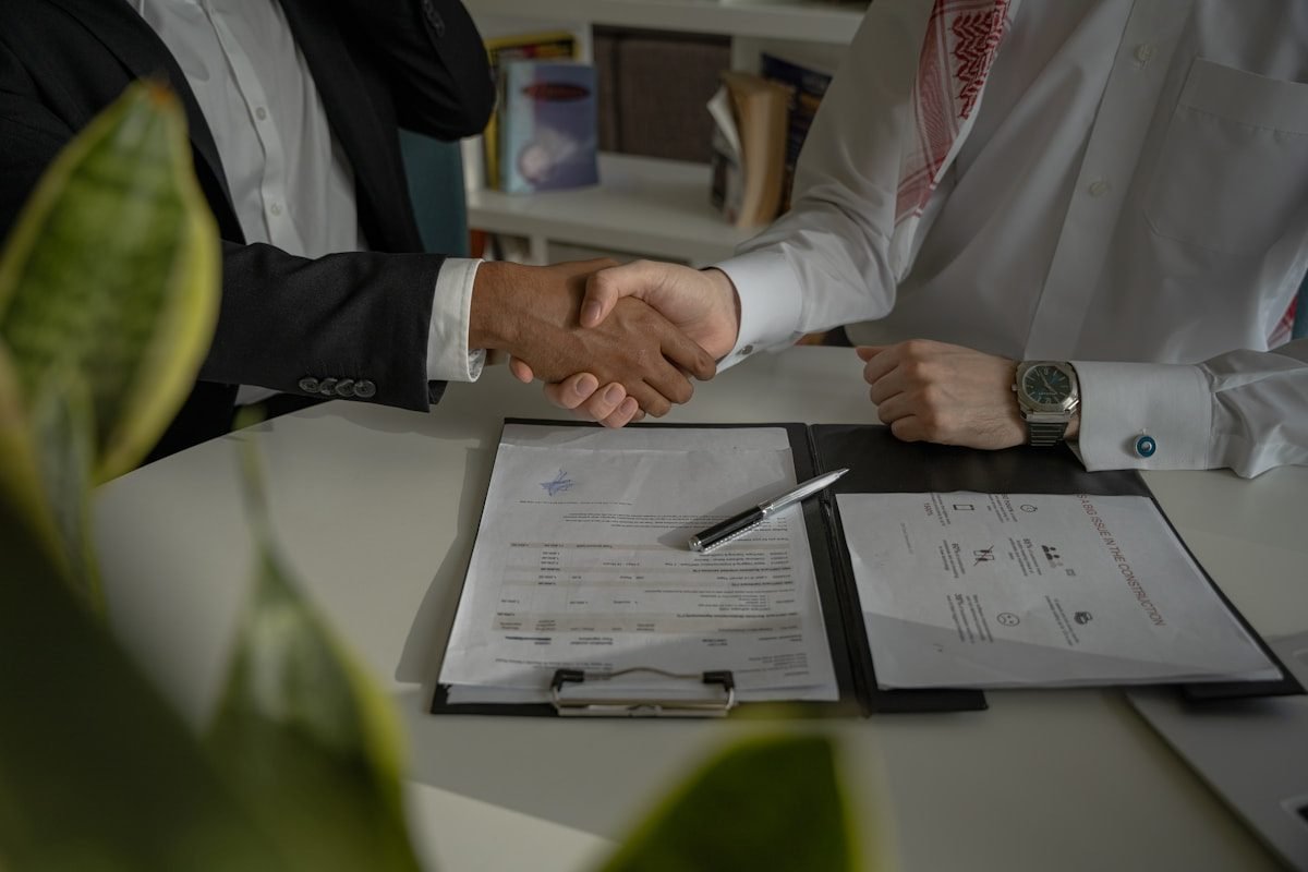 Employer and migration agent shaking hands over a signed labour agreement document